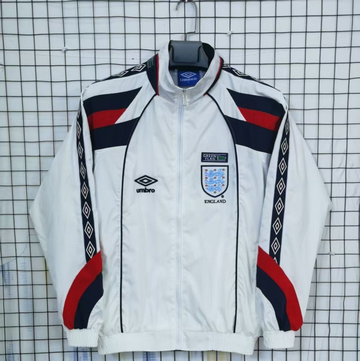 England White tracksuit with red and blue accents on a checkered background
